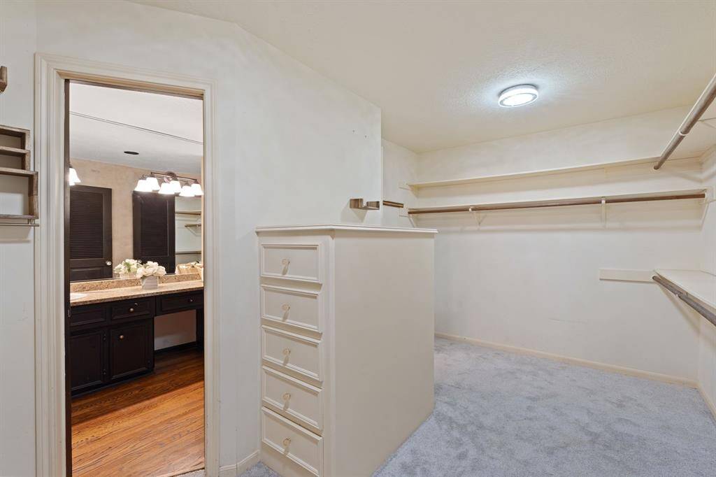 The primary closet features ample shelving, built-in dresser drawers and sensored lights that activate when the doors open.