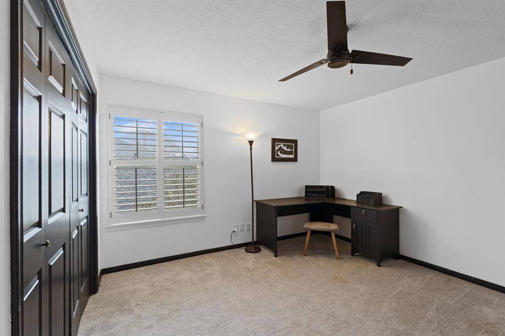 The first guest room is at the top of the stairs to the right and overlooks the right side of the house. It has plantation shutters and custom fan.