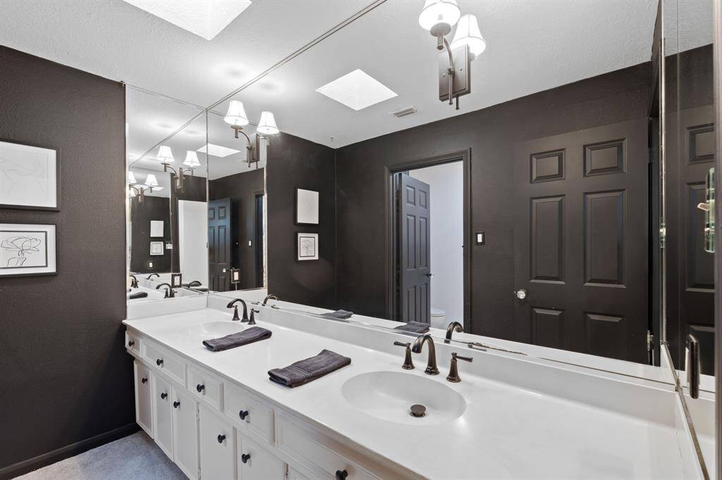 The upstairs guest bathroom has double-vanities, shower/tub combo and additional cabinets for linens.