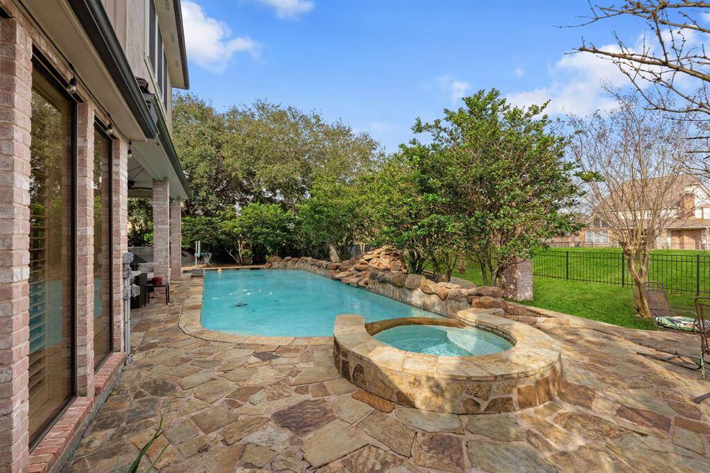 The hot tub spills into the swimming pool for water features.