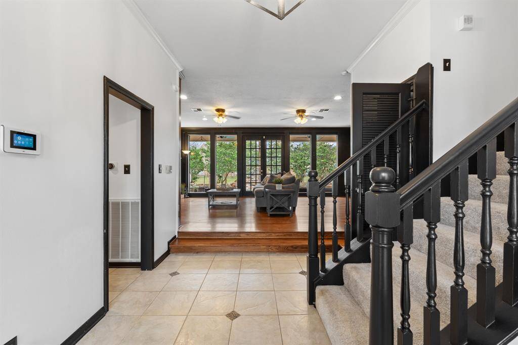 Enter to high ceilings, tile and wood floors and a view through the family room overlooking the swimming pool.