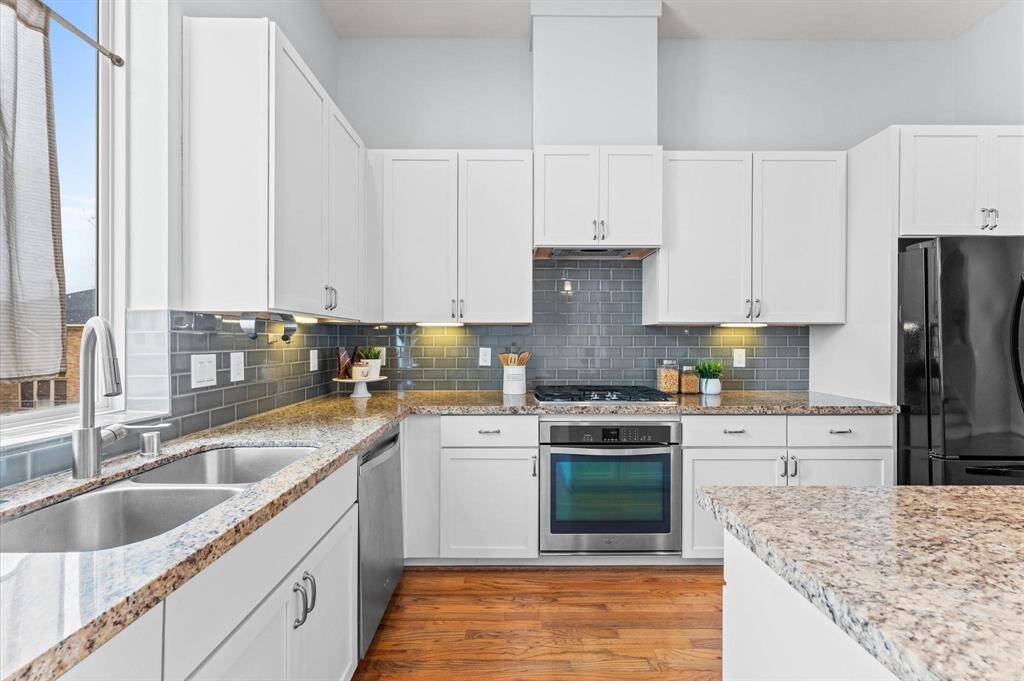 Stainless steel appliances blend seamlessly with the stylish backsplash, making every meal preparation a delight.