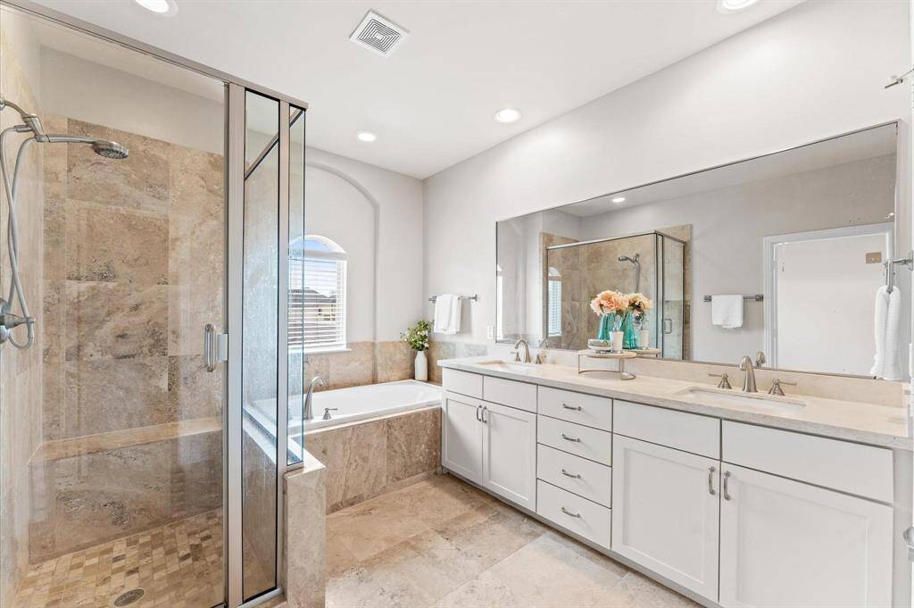 The en suite bathroom is a serene retreat, designed for ultimate relaxation. The dual vanity offers ample space, while the wide mirror reflects soft, natural light, creating a bright and calming ambiance.
