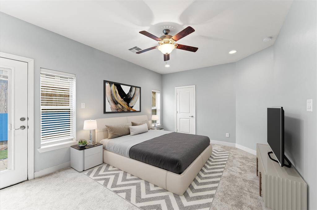A cozy and private retreat, the first-floor bedroom features plush carpet flooring and natural light that pours in through wide windows, creating a warm and inviting ambiance. With easy access to the backyard.
