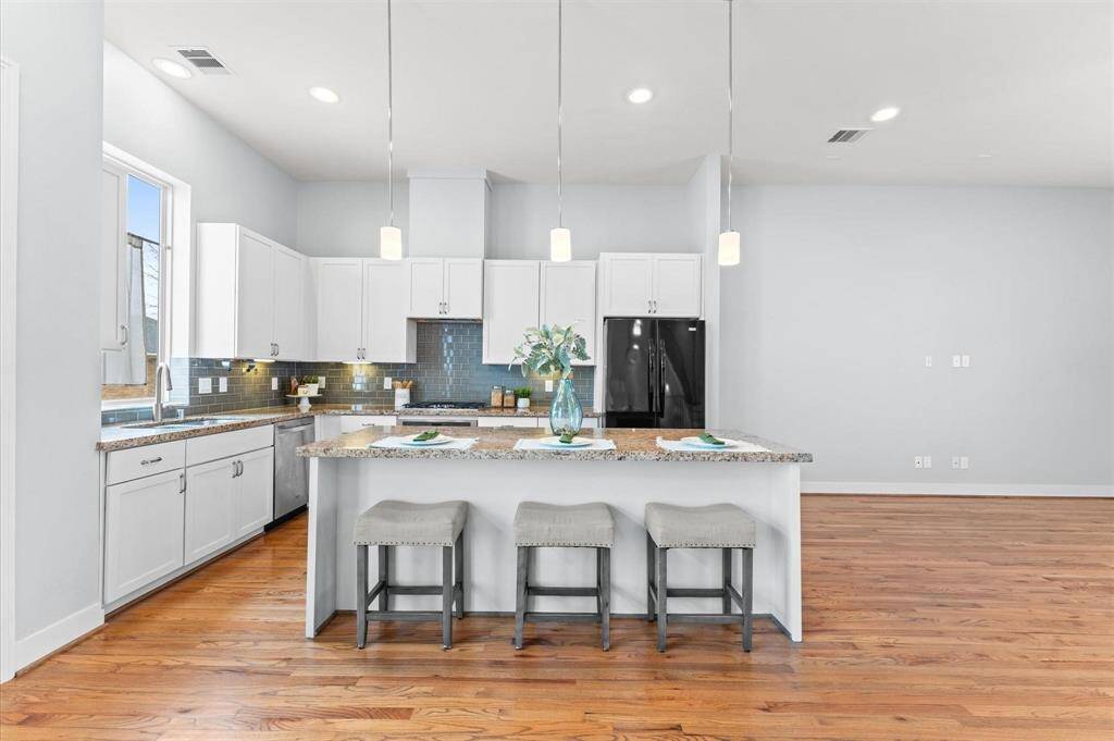 The spacious island, topped with gleaming granite, invites laughter over morning coffee and heartfelt conversations while cooking.