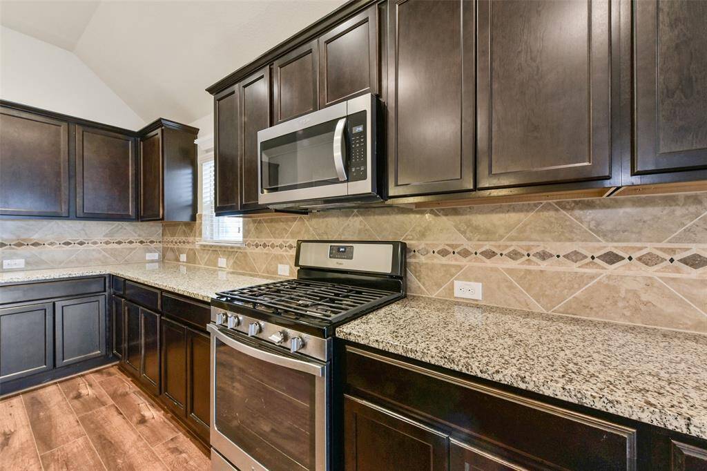 Stainless Appliances including gas range and built-in microwave.
