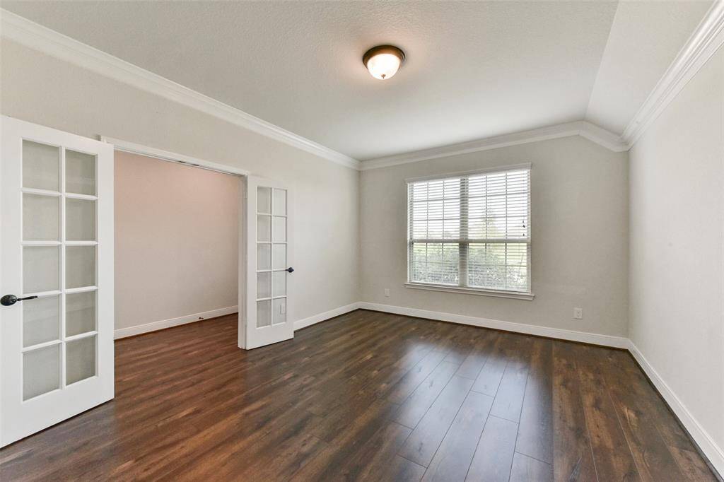 Double glass French doors, wood laminate flooring and crown moulding.