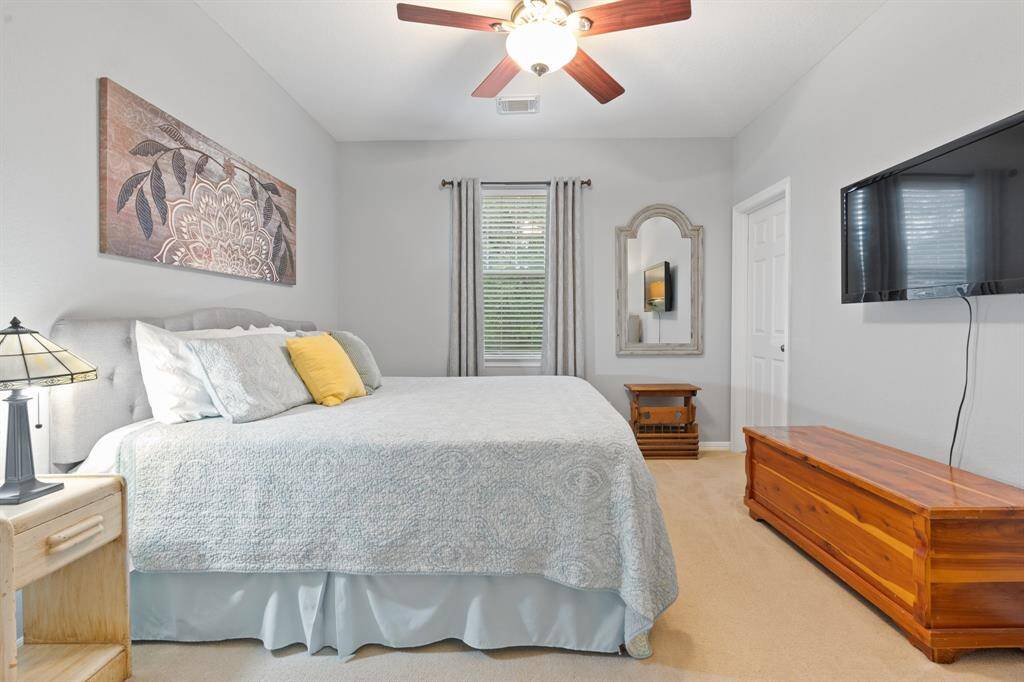 This large bedroom features a large window allowing natural light, creating a cozy and inviting atmosphere.