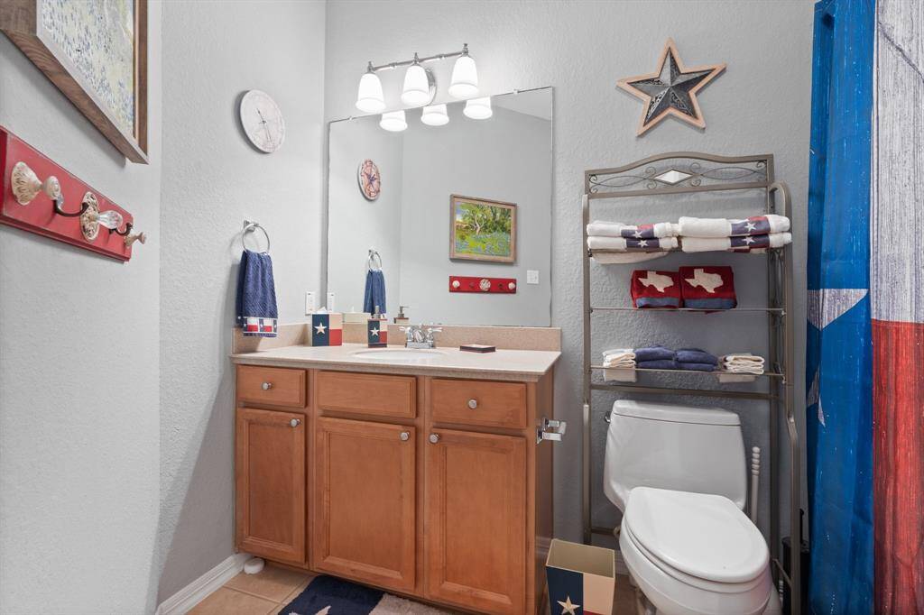 This bathroom features a wooden vanity with a mirror.