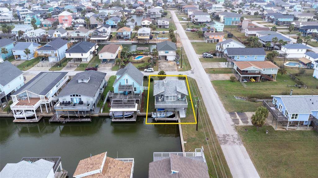 This waterfront property features a charming home with direct canal access, perfect for boating enthusiasts. It's located in a vibrant neighborhood with colorful houses and well-maintained streets, offering a blend of coastal living and community atmosphere.