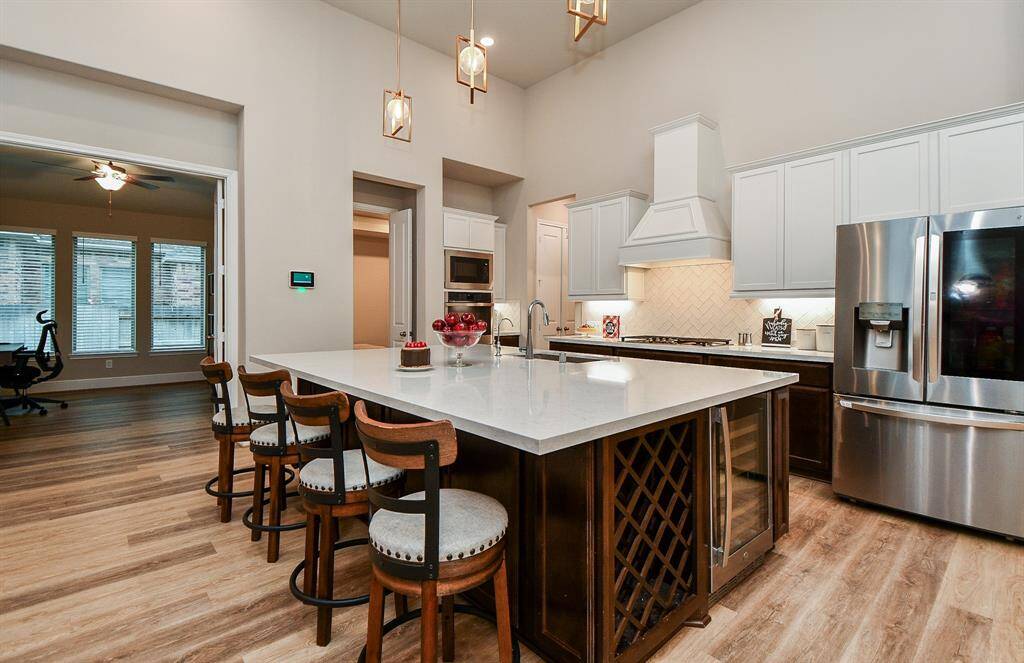 Kitchen is open to the media room on the right next to the ovens and the study/home office with french doors on the right.