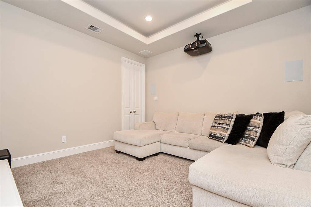 This home theater room has a ceiling-mounted projector, perfect for movie nights.