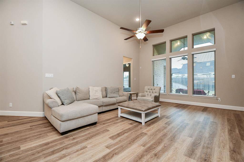 Spacious living room with high ceilings, large windows, and abundant natural light.