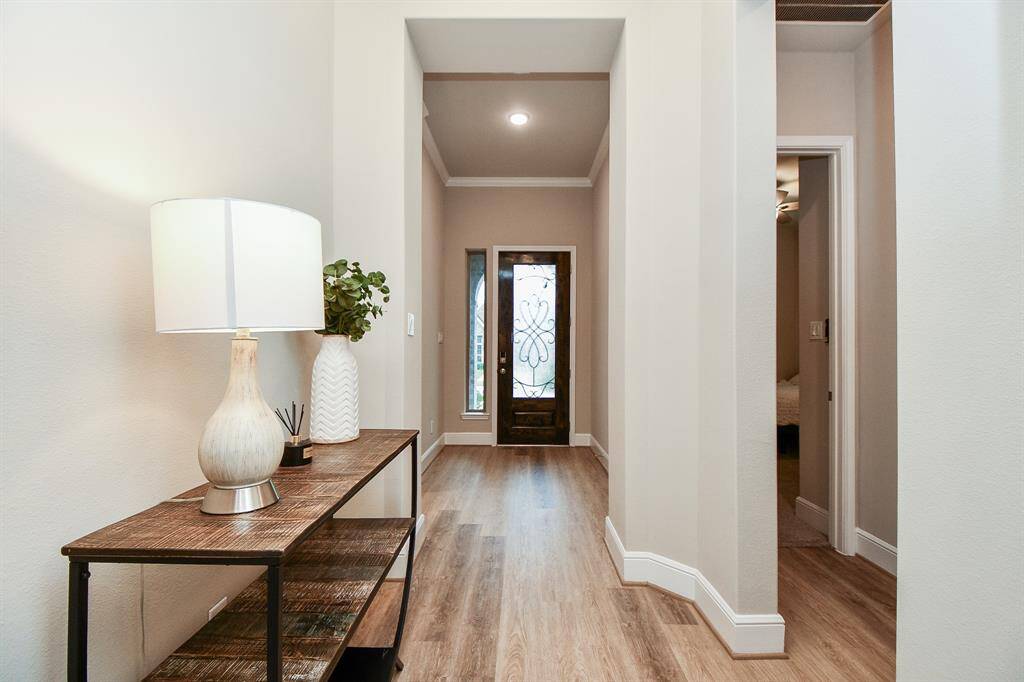 The welcoming foyer leads to a front door with decorative glass panels, offering a warm first impression.