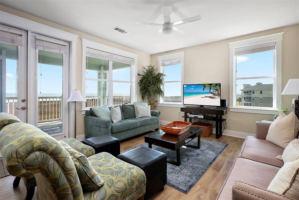 Sun-drenched interiors with panoramic Gulf views set the tone for relaxation, while French doors lead to the expansive balcony for seamless indoor-outdoor living.