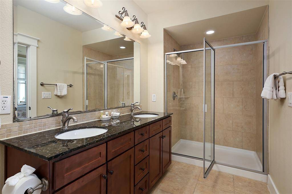 Indulge in the luxury of a dual-sink vanity, granite countertops, a fully tiled walk-in shower, and elegant finishes designed for relaxation.