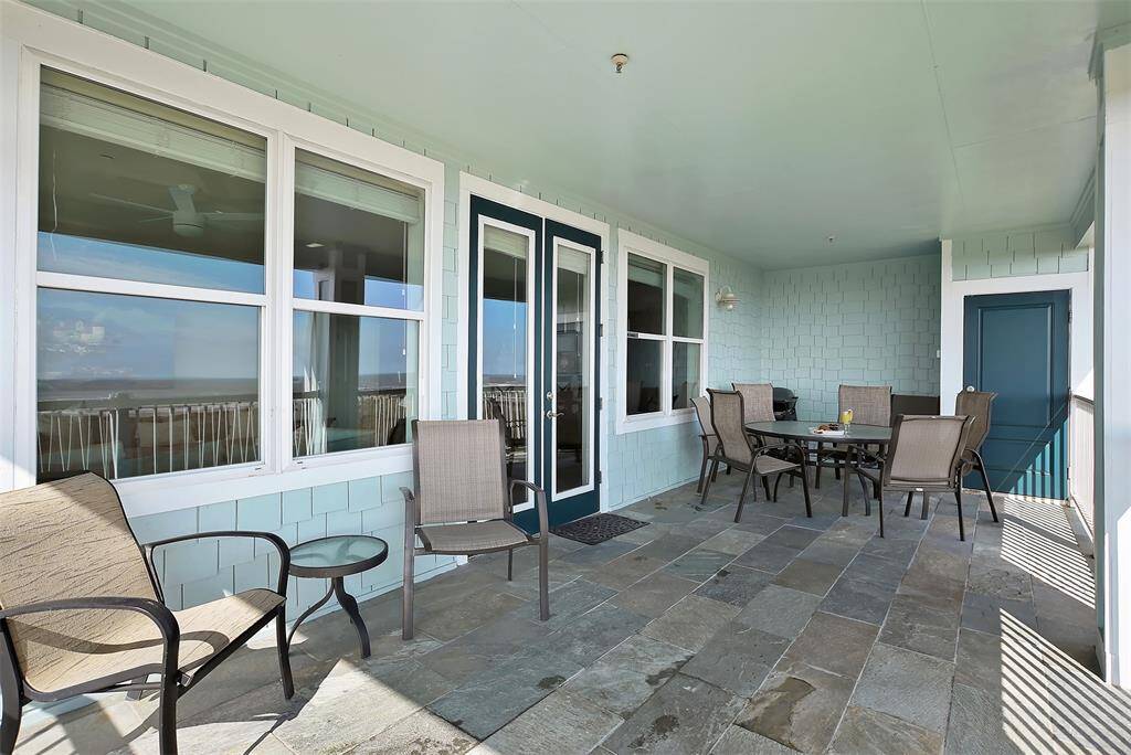 French doors open to a spacious balcony, inviting in natural light and showcasing stunning coastal scenery from your living space.
