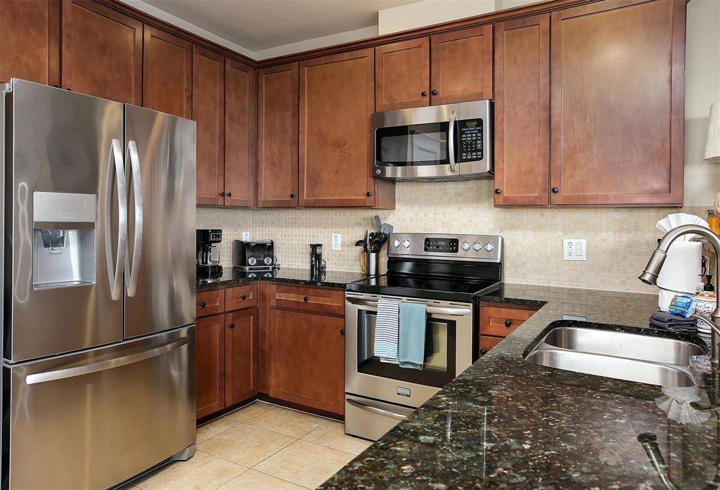 This kitchen is an inviting space for cooking and entertaining, complete with ample storage, a sleek tile backsplash, and premium finishes throughout.