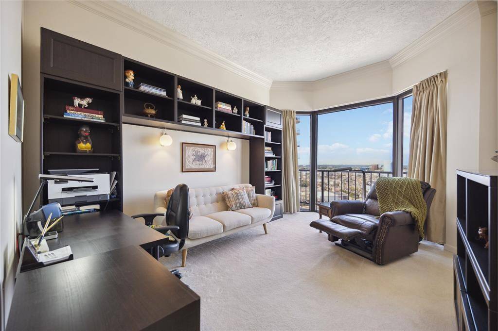 Secondary bedroom with built in shelving and floor to ceiling windows