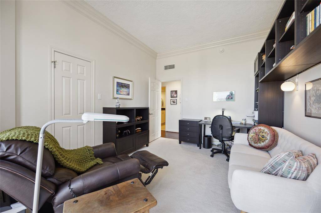 Large walk in closet with professional closet organization system in secondary bedroom