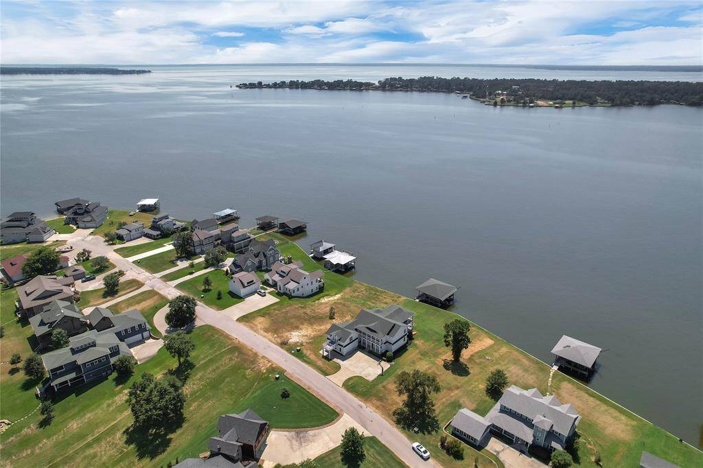 This photo shows a serene lakeside neighborhood with spacious homes, some featuring private docks. The area offers stunning water views and a peaceful, scenic environment, ideal for those seeking a waterfront lifestyle.