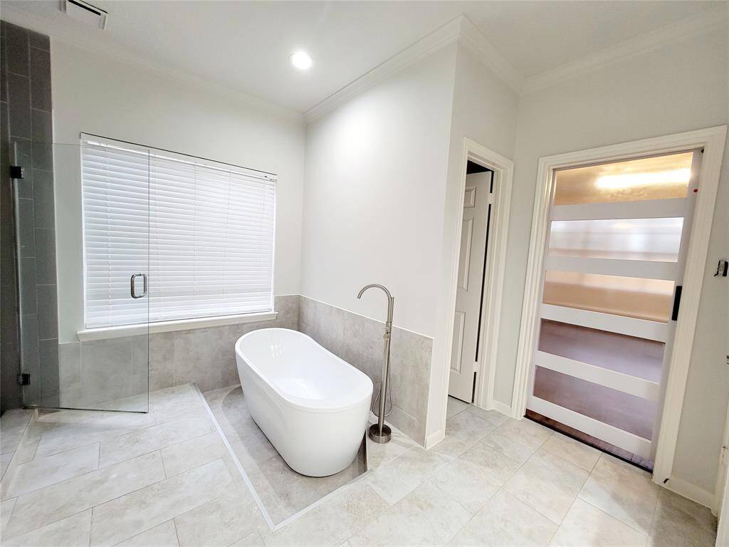 Master bath has his and her closets.