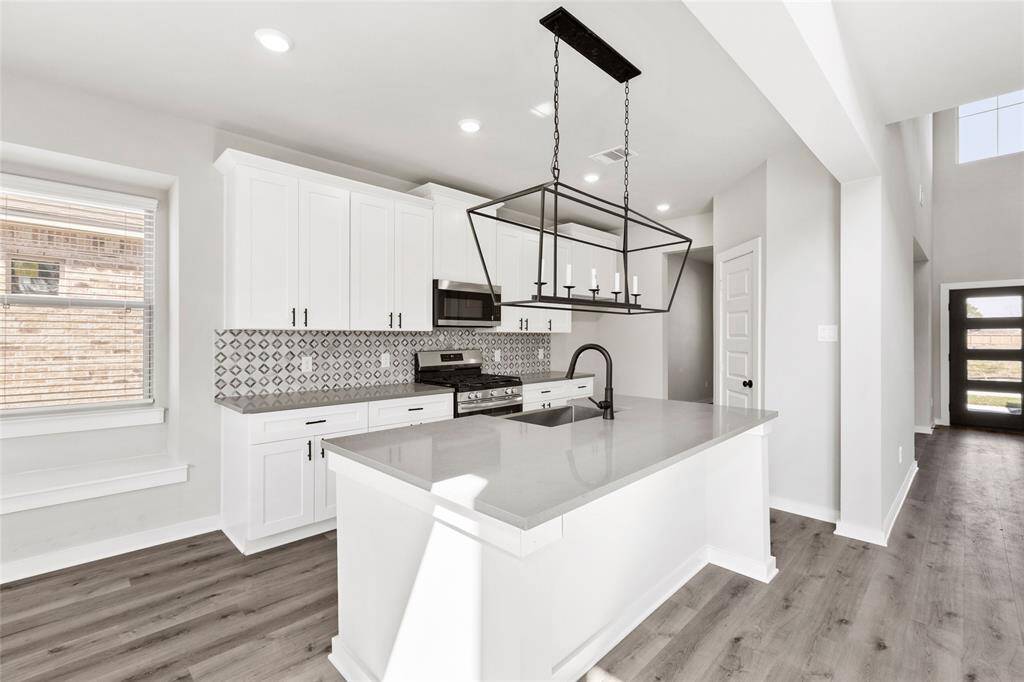 This modern two-story home features a spacious front yard, a double garage, and a sleek exterior design with neutral tones. Located in a suburban neighborhood, it offers a welcoming atmosphere and ample living space.