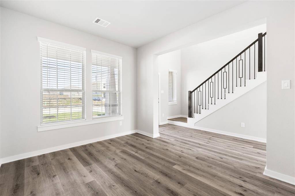 This modern two-story home features a spacious front yard, a double garage, and a sleek exterior design with neutral tones. Located in a suburban neighborhood, it offers a welcoming atmosphere and ample living space.