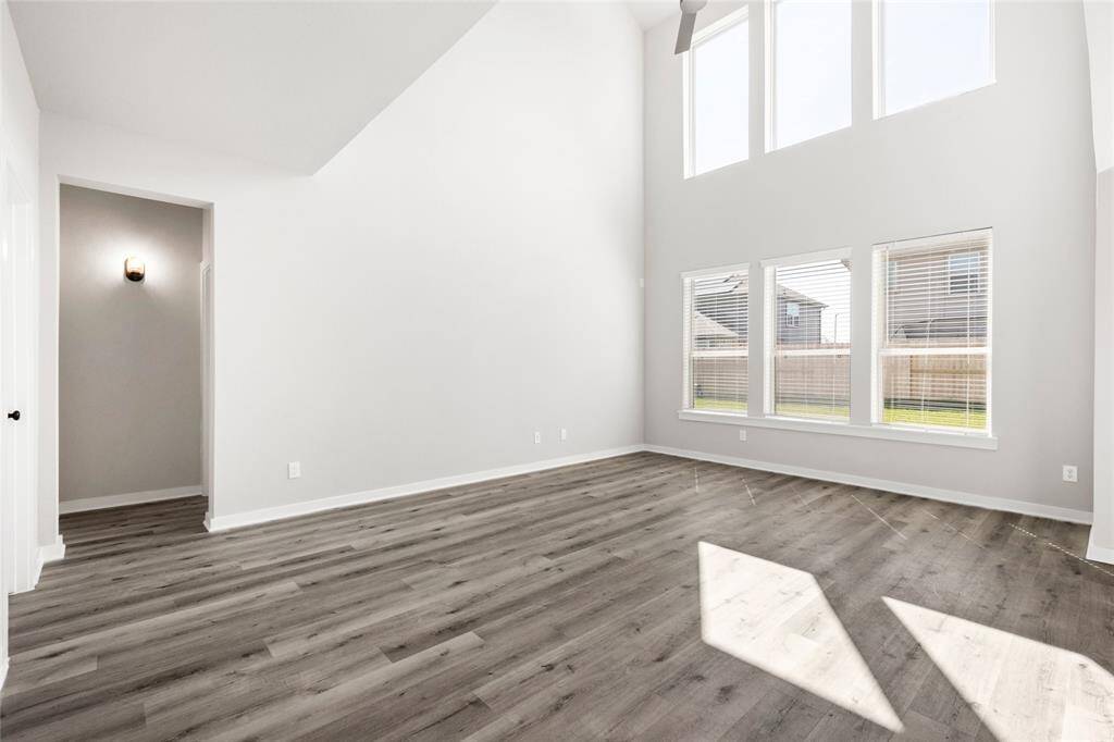This modern two-story home features a spacious front yard, a double garage, and a sleek exterior design with neutral tones. Located in a suburban neighborhood, it offers a welcoming atmosphere and ample living space.