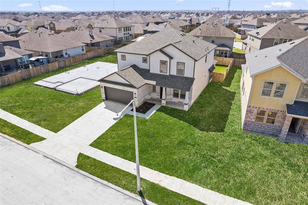 This modern two-story home features a spacious front yard, a double garage, and a sleek exterior design with neutral tones. Located in a suburban neighborhood, it offers a welcoming atmosphere and ample living space.