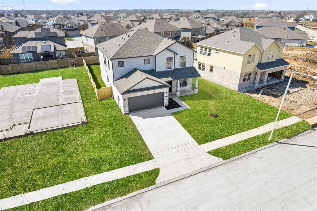 This modern two-story home features a spacious front yard, a double garage, and a sleek exterior design with neutral tones. Located in a suburban neighborhood, it offers a welcoming atmosphere and ample living space.