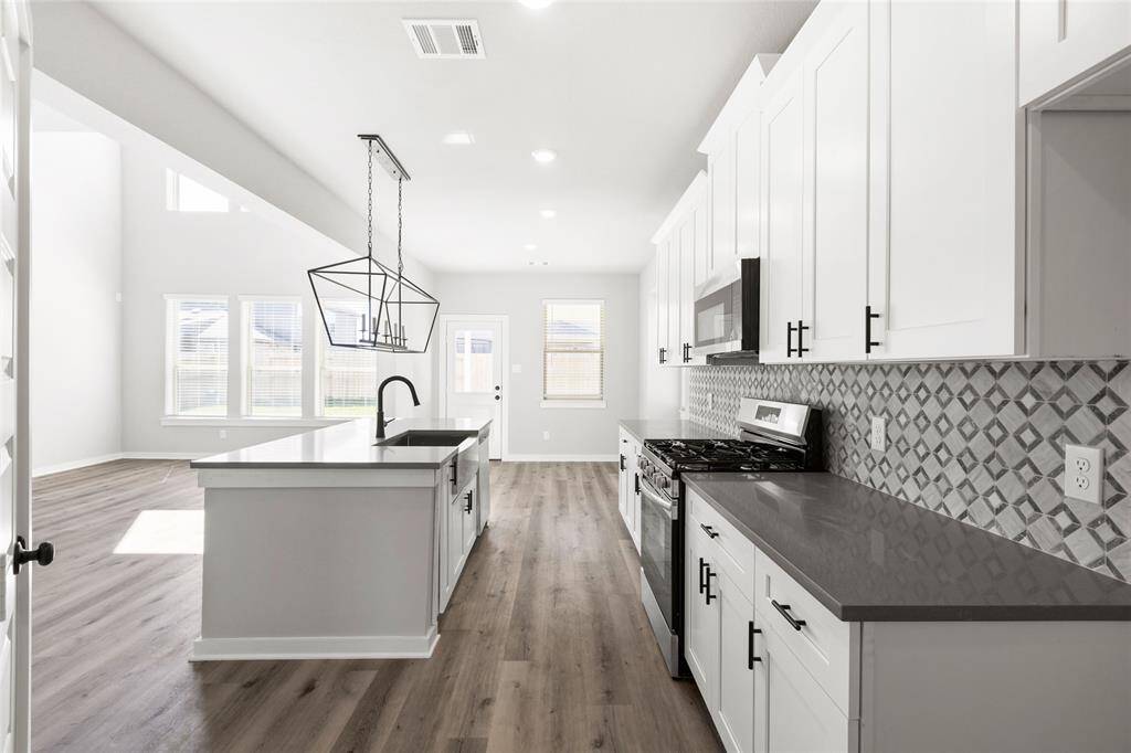 This modern two-story home features a spacious front yard, a double garage, and a sleek exterior design with neutral tones. Located in a suburban neighborhood, it offers a welcoming atmosphere and ample living space.