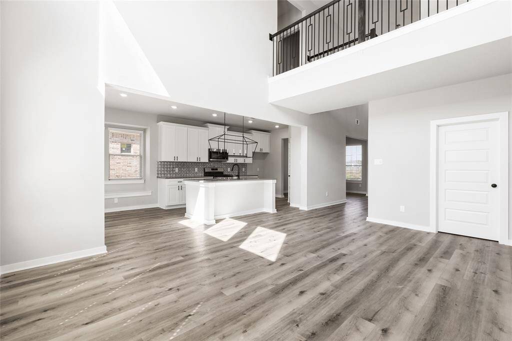 This modern two-story home features a spacious front yard, a double garage, and a sleek exterior design with neutral tones. Located in a suburban neighborhood, it offers a welcoming atmosphere and ample living space.