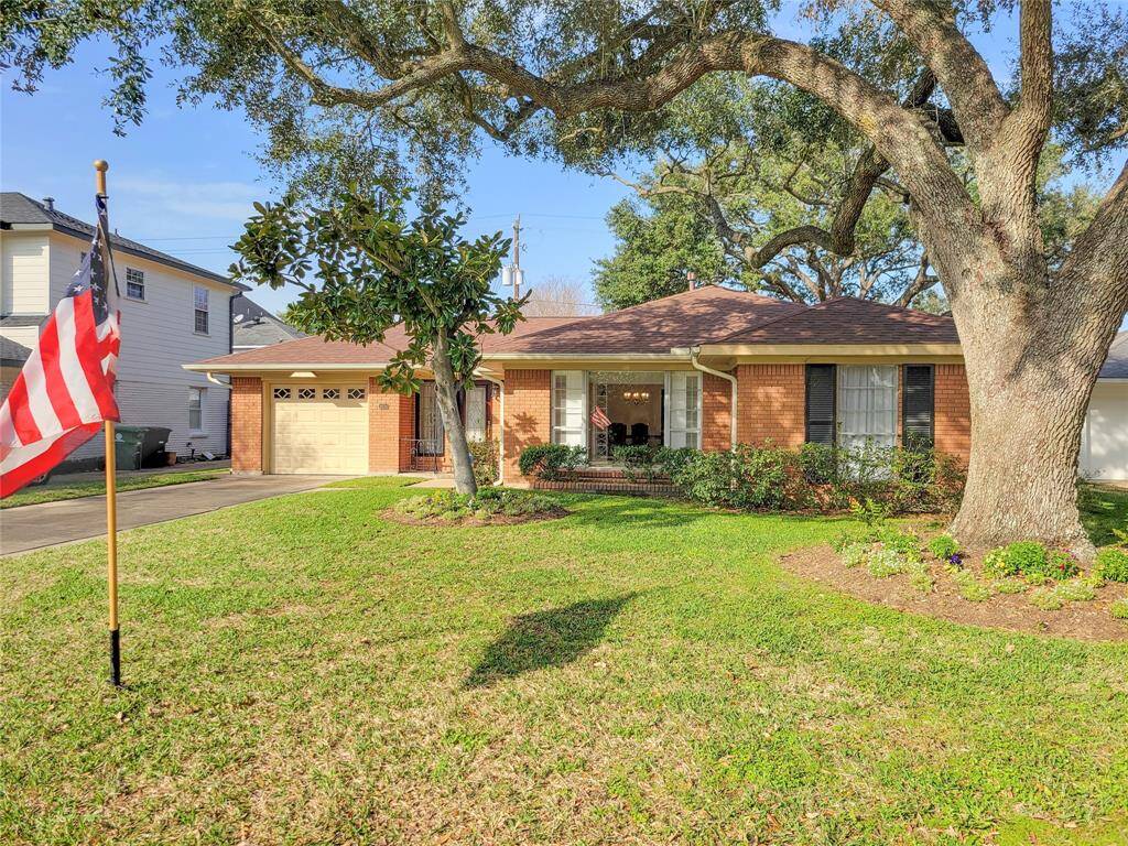 Charming single-story brick traditional home with an attached garage, featuring mature trees and well maintained landscaping.