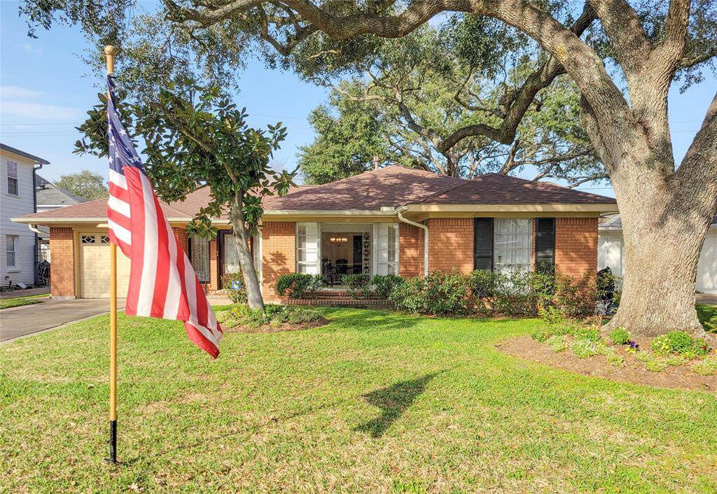This charming brick home features a well-maintained front yard with mature trees. The American flag adds a patriotic touch, and the property includes a convenient attached garage. Perfect for those seeking a cozy, welcoming atmosphere.