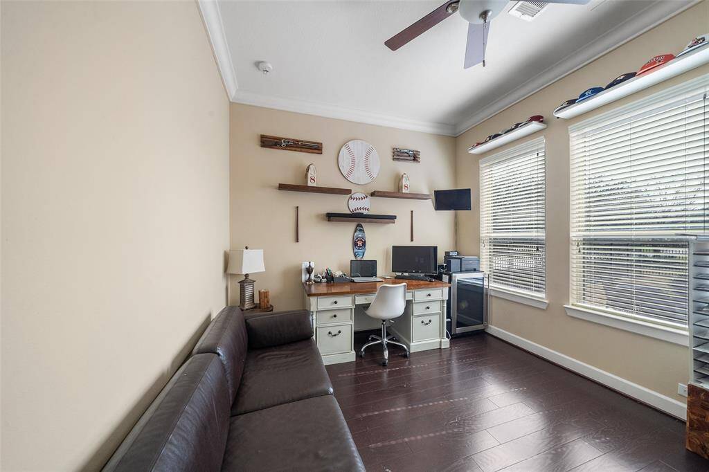 This downstairs bedroom is being used as a home office, has large windows allowing natural light.