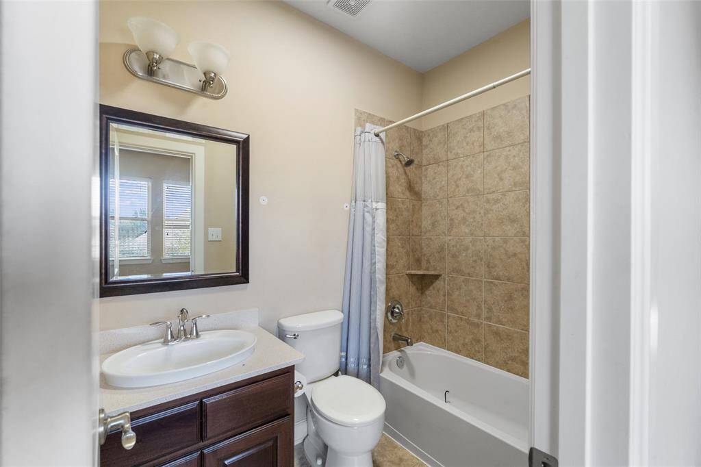 This 3rd bathroom features a modern design with a tiled shower-bathtub combo. Neutral walls and tile flooring provide a clean, spacious feel.