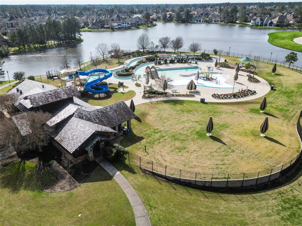 One of the many community recreational areas with a swimming pool, water slide, and playground, set beside a scenic lake. The area includes green spaces and a clubhouse, ideal for family activities and relaxation.