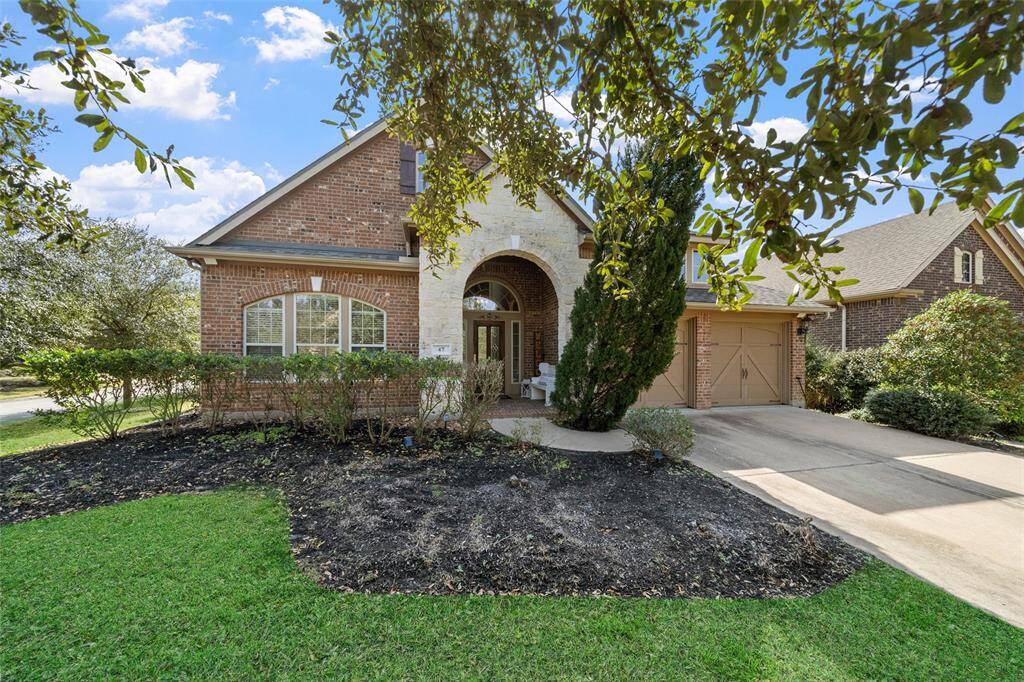Charming brick home with a welcoming arched entryway, spacious driveway, and well-maintained landscaping. Features a three-car garage and large windows for natural light. Ideal for comfortable family living in a serene neighborhood.