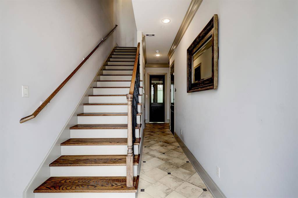 Inviting foyer with travertine designed flooring welcomes you home. Carefree maintenance year round.  Enter foyer from garage or front door. Take the hardwood stairs to 2nd floor or ride in the wood paneled custom elevator located to right of stairway.  Custom trim, crown molding, 5" baseboards throughout home.  Coat closet under stairway to grab last minute items needed. Garage door to right and door with glass insert leads to study/office.  1st fl private patio located off study/office.