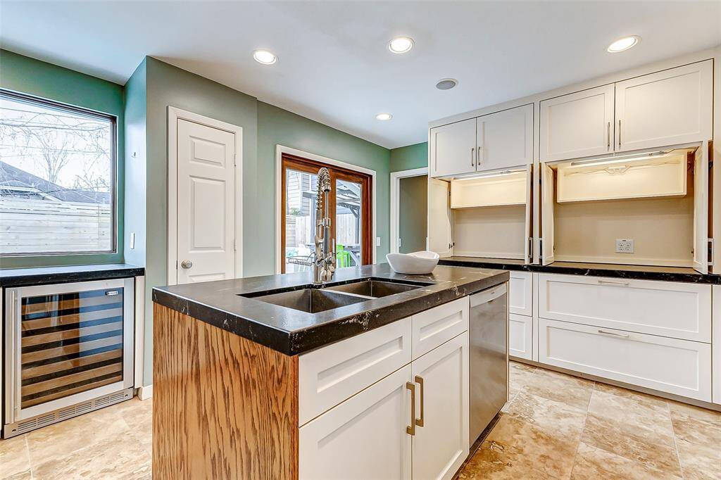 Experience luxury in this custom kitchen with a wine refrigerator and sleek appliance garages.