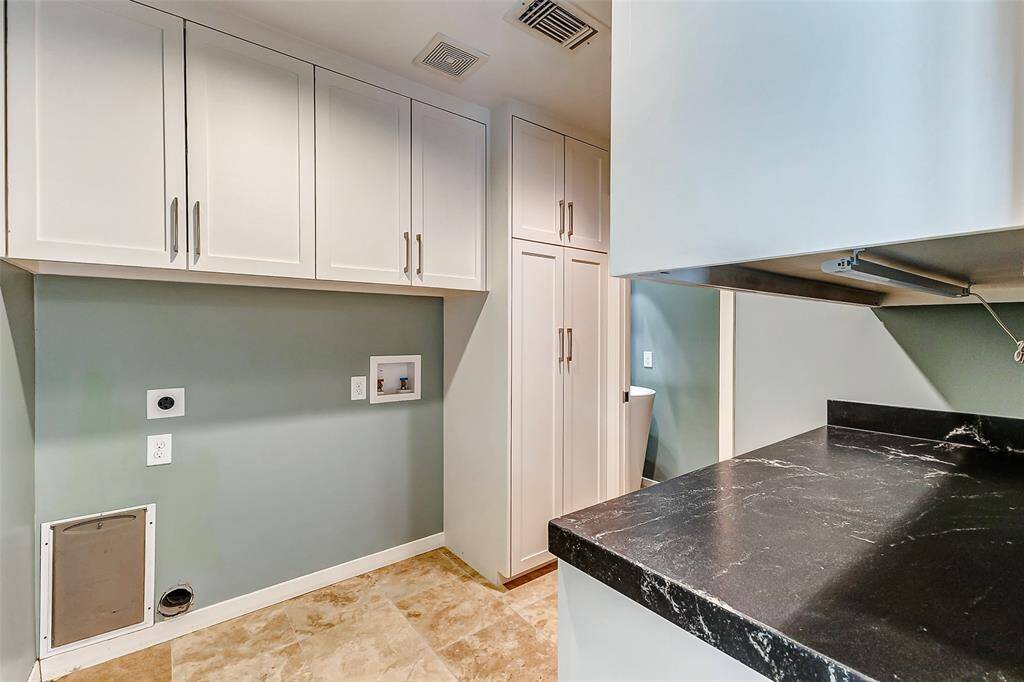 Indoor laundry room with granite countertops and extra storage, plus a charming half bath discreetly located at the back.