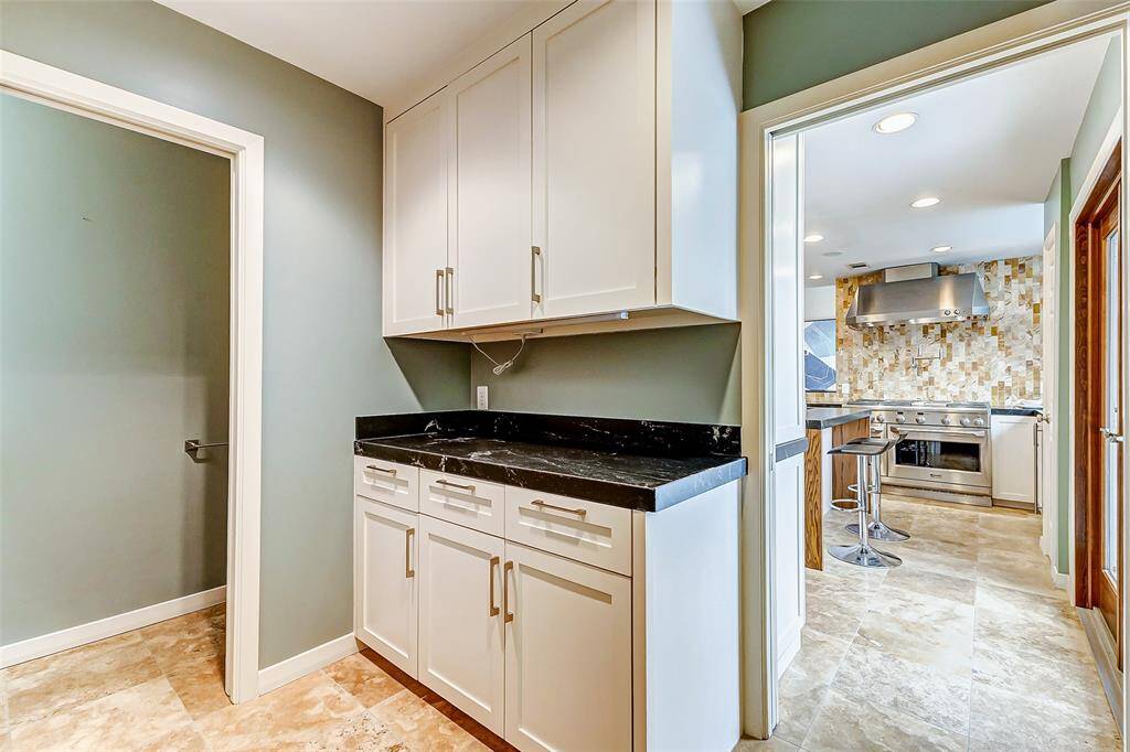 Conveniently located off the kitchen, the laundry room and half bath provide easy access to the pool area.