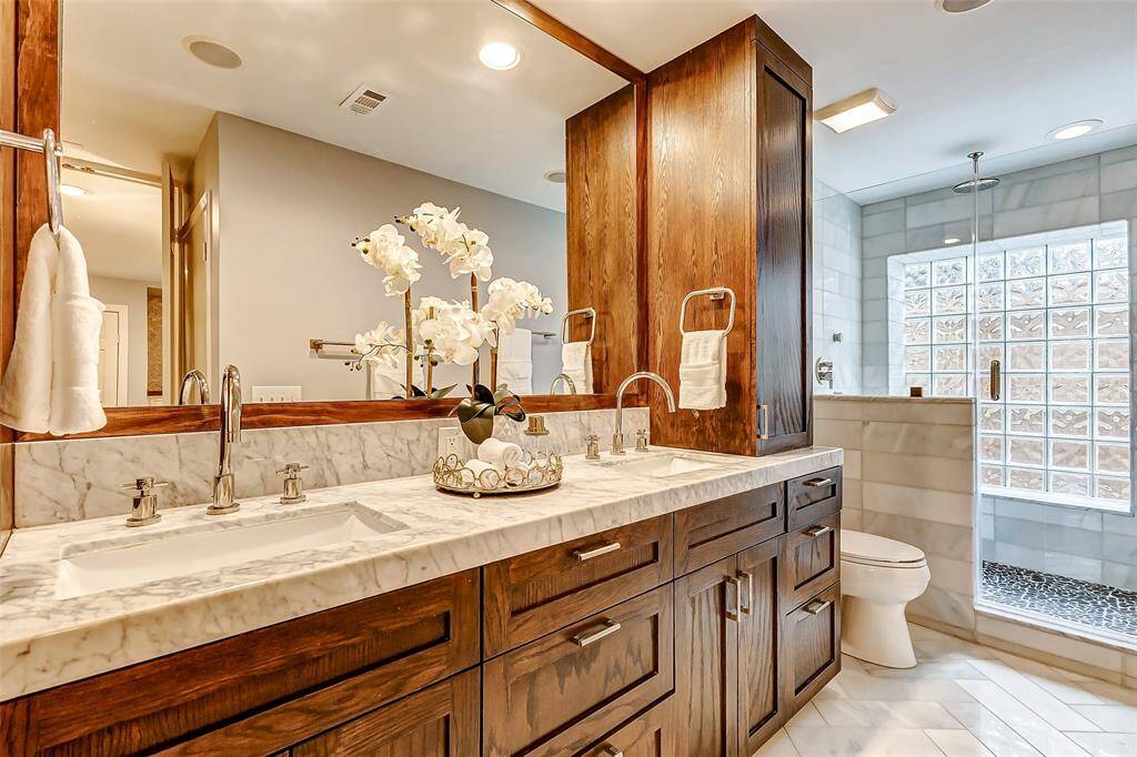 Indulge in luxury with this primary bathroom featuring marble countertops, dual sinks, and a spacious walk-in shower.