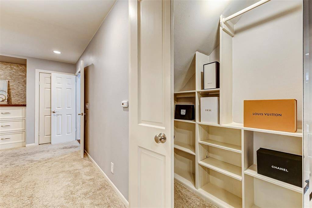 Spacious primary closet with ample shelving for organized storage.