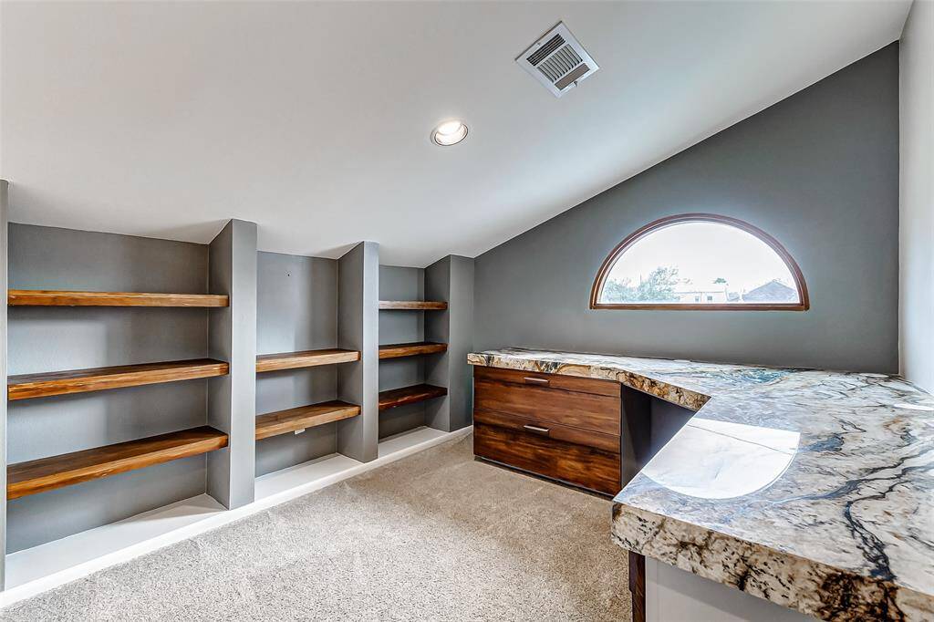 Cozy office nook featuring custom bookshelves and a granite-top desk.