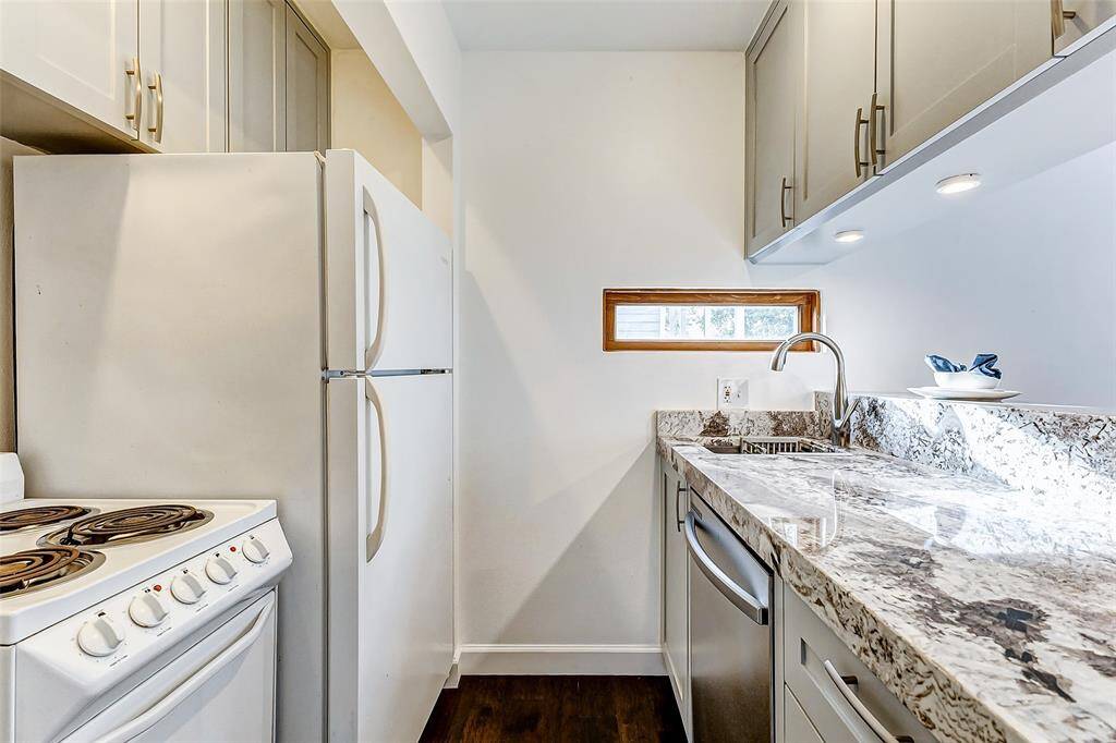 Discover the charm of this cozy kitchen featuring elegant granite countertops, a full-size dishwasher, refrigerator, and a 4-burner stove—perfect for all your needs!