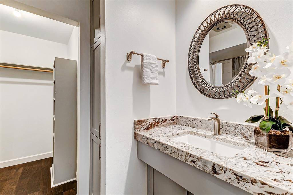 This stylish 2019-renovated bathroom in the garage apartment features granite countertops, ample storage, and a spacious walk-in closet.