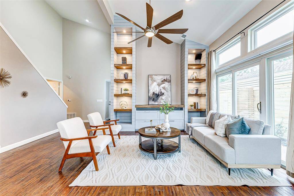 Experience elegance with custom cabinets, soaring ceilings, and sleek engineered wood flooring in the open living room.