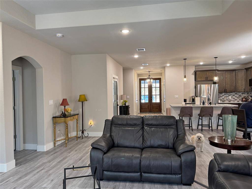 Facing the front door and kitchen from the living room.
